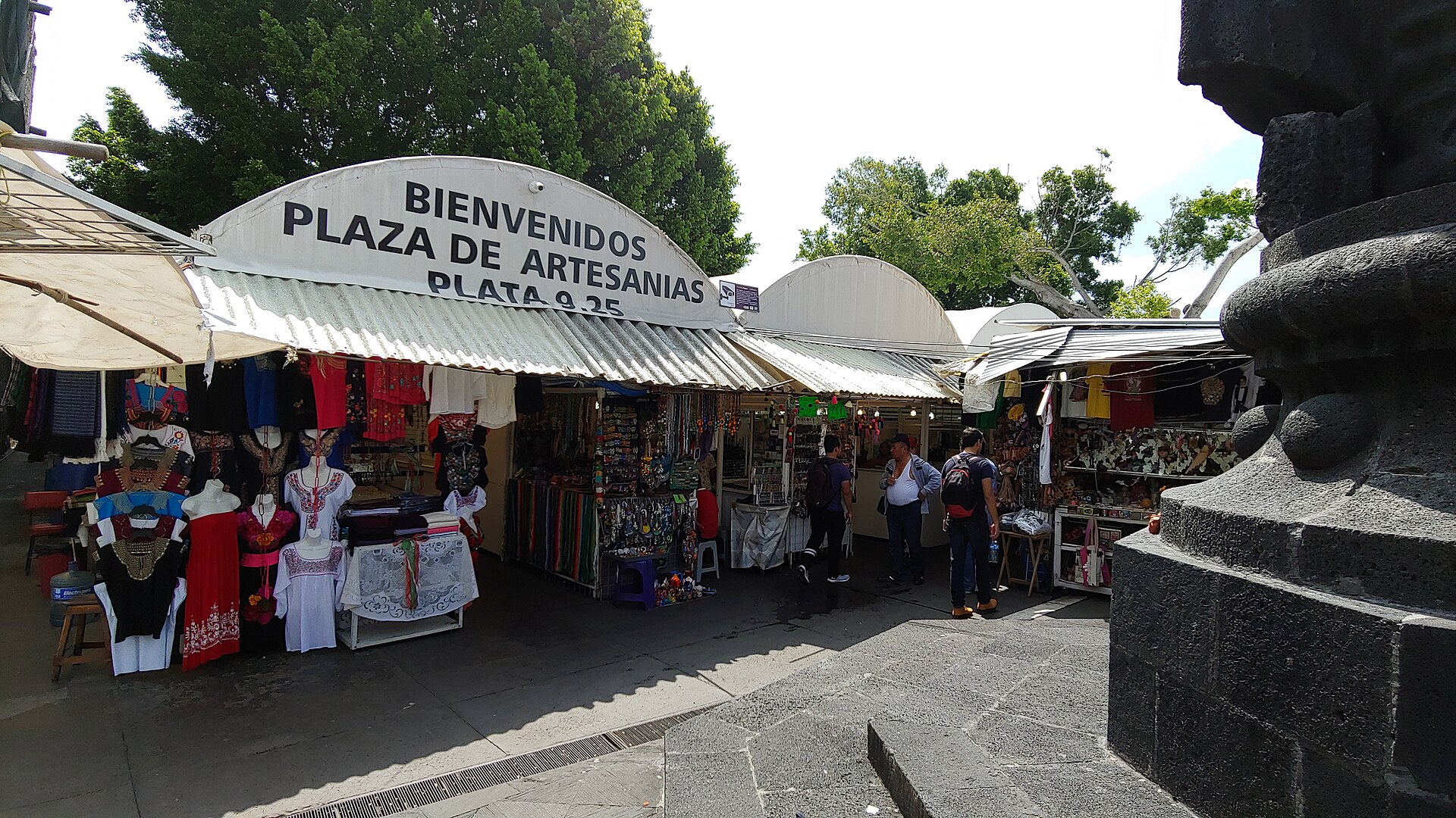 Entrada a la Plaza de Artesanías de Cuernavaca, con puestos y visitantes.
