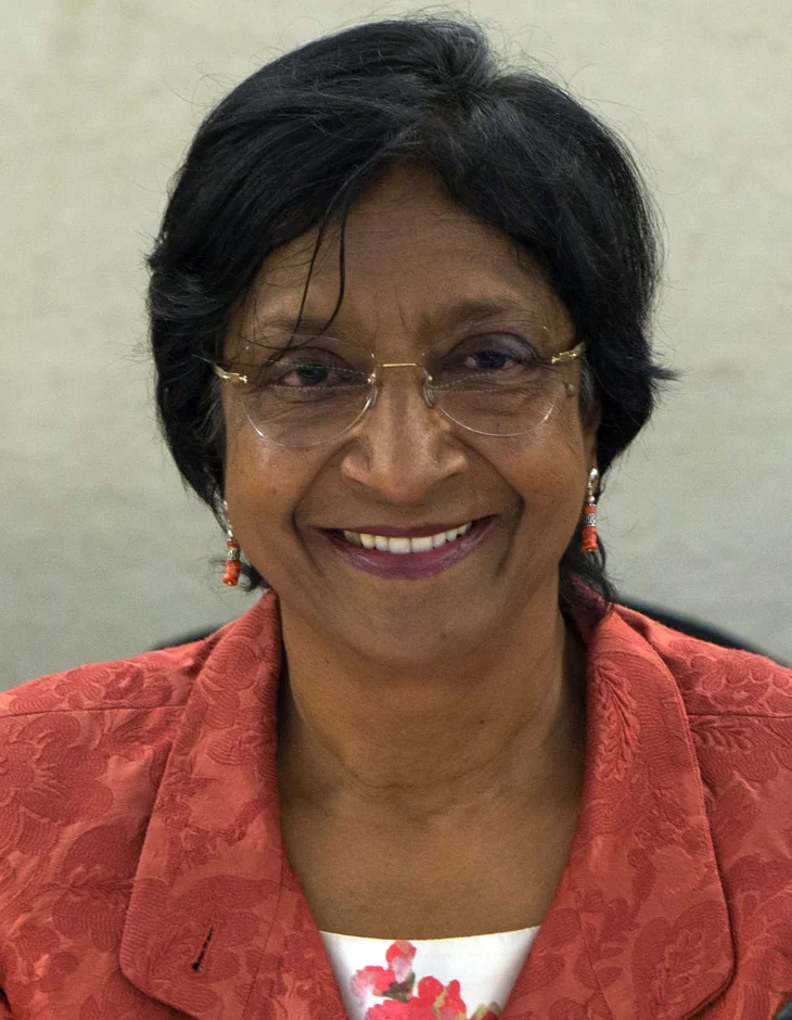 Retrato de Navi Pillay con lentes y chaqueta roja.